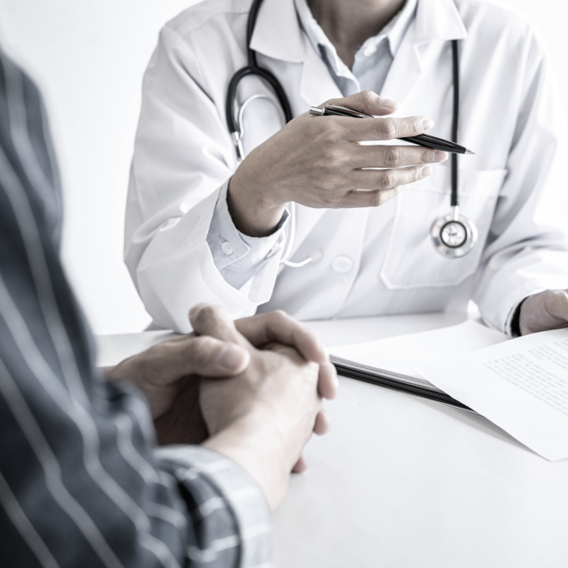 closeup of patient and doctor holding a pen