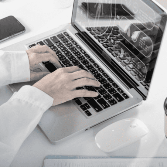 a doctor types on a laptop