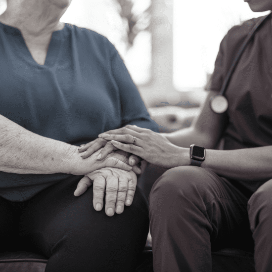 closeup of a nurse holding an elderly patient's hand